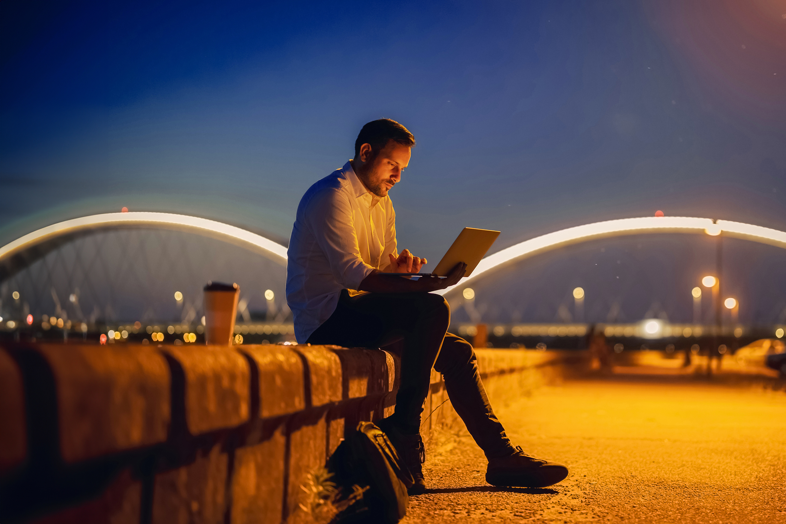 Man using laptop at the night in the city